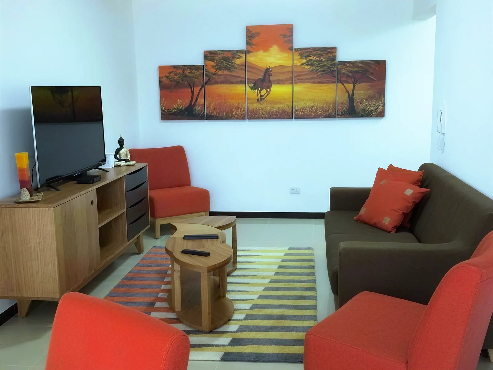 Living and dining room with sofa, armchairs and a flat-screen TV